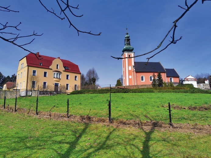 	Po lewej dom zakonny przejęty po siostrach służebniczkach. Po prawej kościół parafialny pw. Zwiastowania NMP, obsługiwany przez księży diecezjalnych. 