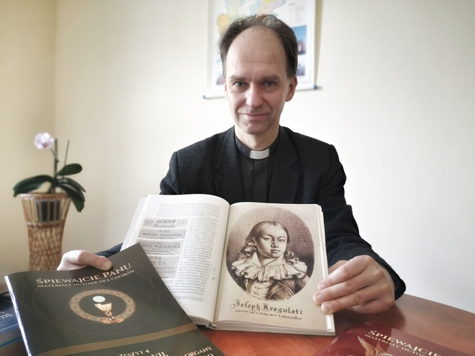 Ks. Grzegorz Piekarz.Duchowny prezentuje monografię o Krogulskim, a także wydanie Mszy nr 7, przygotowane przez Wydział Muzyki Kościelnej.