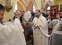 Diakon z Pismem Świętym obchodzi świątynię i jest okadzany przez jednego z kapłanów.