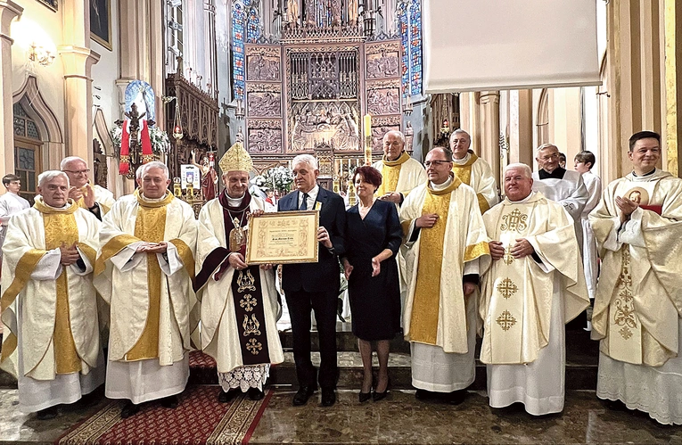 Odznaczony samorządowiec z małżonką i kapłanami.