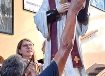 „Groźny woźny” poprawia liść palmy, który od lat „kusi” licealistów do wyjmowania go z ręki świętego.