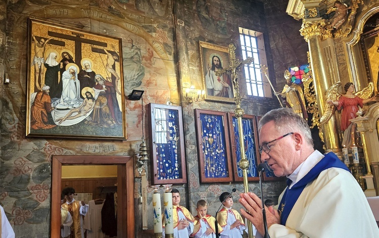 	Obraz poświęcił ks. Stanisław Pachowicz. Malowidło znalazło się w oryginalnym miejscu, nad wejściem z prezbiterium  do zakrystii.