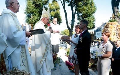 Przekazanie bochna przez starostów dożynkowych.