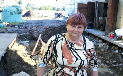 Bogusława Korszyłowska na podwórku domu. Za nią lej po przejściu wody.