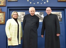 Barbara Sawczyk, ks. proboszcz Jan Mikulski i ks. Łukasz Bochenek na tle błękitnej ściany – bramy.