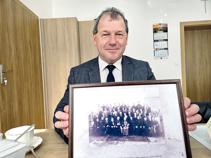 	Jerzy Wałęga z fotografią z otwarcia domu z 1931 roku. 