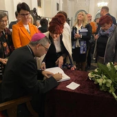 Podczas spotkania bp W. Osial podpisywał swoją publikację.