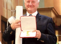 Uroczysta chwila wręczenia medalu w świątyni katedralnej.