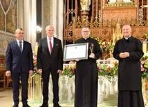 Ks. Tomasz Pastuszka, nagrodzony duszpasterz, ze statuetką i dyplomem.