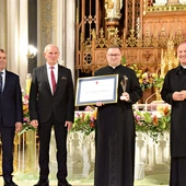 Ks. Tomasz Pastuszka, nagrodzony duszpasterz, ze statuetką i dyplomem.