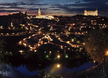 Panorama Toledo.  Ta dawna stolica  państwa Wizygotów  i późniejsza stolica Królestwa Hiszpanii została odzyskana  przez chrześcijan w 1085 roku. Dwa najbardziej oświetlone obiekty to gotycka katedra (w środku)  i alkazar (z prawej)  – dawna twierdza,  obecnie Muzeum Wojska.
