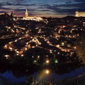 Panorama Toledo.  Ta dawna stolica  państwa Wizygotów  i późniejsza stolica Królestwa Hiszpanii została odzyskana  przez chrześcijan w 1085 roku. Dwa najbardziej oświetlone obiekty to gotycka katedra (w środku)  i alkazar (z prawej)  – dawna twierdza,  obecnie Muzeum Wojska.