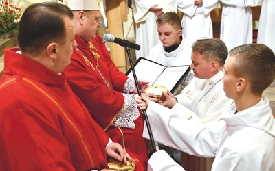	Biskup w czasie udzielania posługi powierza naczynie z chlebem do sprawowania Eucharystii.