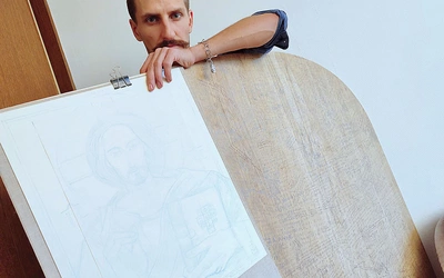 Paweł Modzelewski przy desce, na której będzie tworzył.