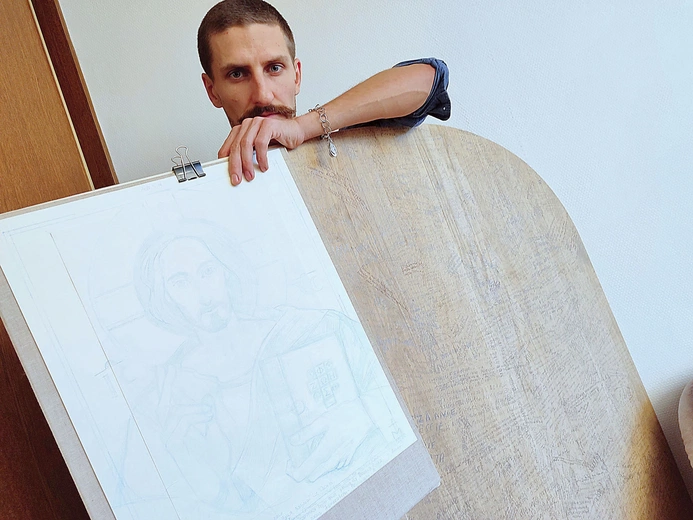 Paweł Modzelewski przy desce, na której będzie tworzył.