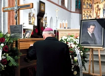 Biskup modli się przy trumnie zmarłego.