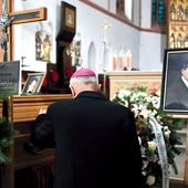 Biskup modli się przy trumnie zmarłego.
