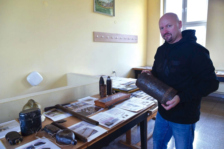 Piotr Styrna prezentuje artefakty zgromadzone na wystawie.