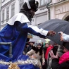 Król afrykański w drodze do stajenki śpiewa kolędy i rozdaje dzieciom cukierki.