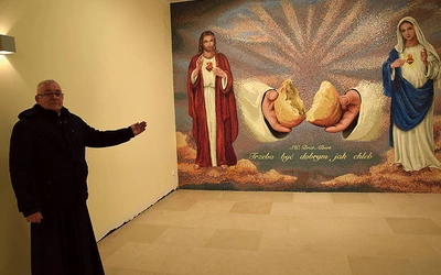 Ks. Artur Fura prezentuje mozaikę z Jezusem i Maryją.