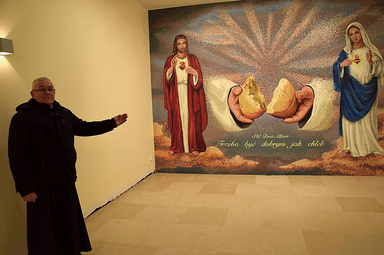 Ks. Artur Fura prezentuje mozaikę z Jezusem i Maryją.