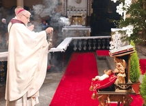 Bp Marek Mendyk okadza figurkę Dzieciątka.