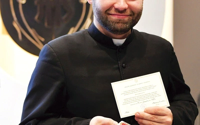 	Ksiądz Damian Drop prezentuje relikwie.