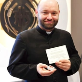 	Ksiądz Damian Drop prezentuje relikwie.