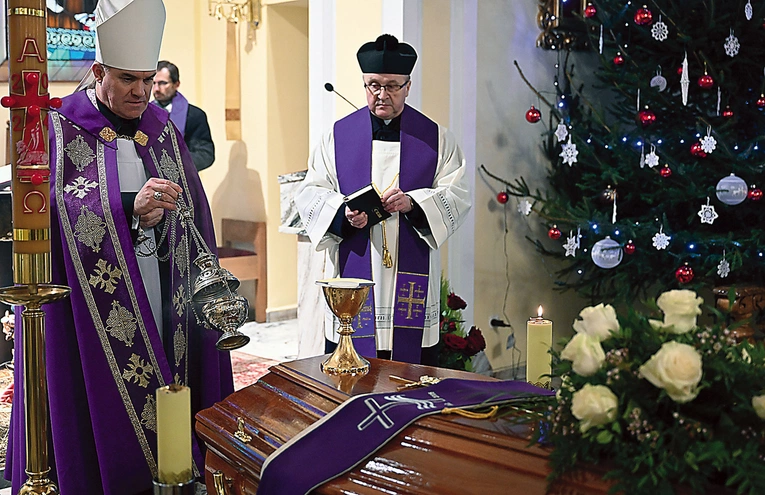 Biskup okadza trumnę z ciałem.