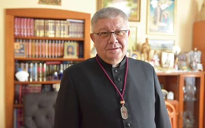 Ks. Józef Drabik z medalem, który otrzymują osoby należące do organizacji.