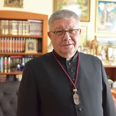 Ks. Józef Drabik z medalem, który otrzymują osoby należące do organizacji.