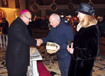 Bp Jacek Kiciński CMF składa gratulacje członkom Żywego Różańca.  Wśród nich jest zelatorka, Teresa Drozd.
