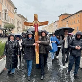 Pielgrzymi idą z krzyżem do bazyliki św. Piotra.