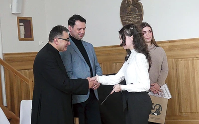 Ks. Grzegorz Gruszecki i dyrektor I LO Jacek Biłko, którzy ponownie patronują konkursowi, z laureatkami ubiegłorocznej gali.