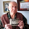 	Stanisław Talaga ze zdjęciem grupy ministranckiej z 1945 roku. Za nim na ścianie wisi portret jego mamy Magdaleny,  która spowiadała się u sługi Bożego.