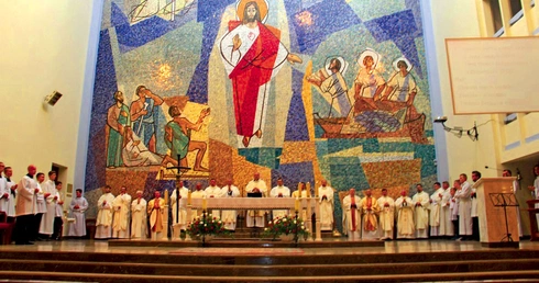 	Monumentalna mozaika w prezbiterium zaprojektowana została przez Bogumiła Marszala.