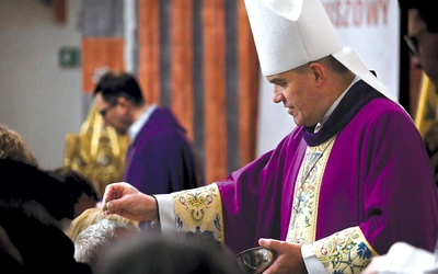 	Biskup posypuje popiołem głowy wiernych w koszalińskiej katedrze.