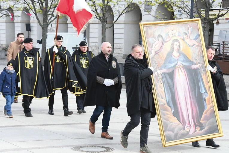 Mężczyźni noszą duży obraz  Matki Bożej Łaskawej  i sztandar św. Andrzeja Boboli.