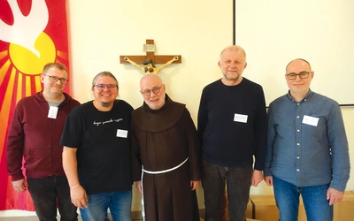 Mężczyźni z „Zacheusza” pomagają franciszkaninowi w posłudze osadzonym.