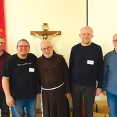 Mężczyźni z „Zacheusza” pomagają franciszkaninowi w posłudze osadzonym.