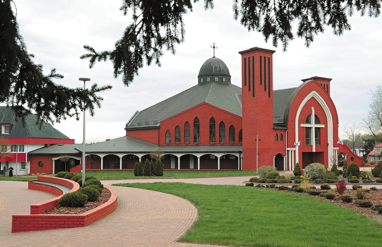 Gigantyczny ceglano-biały kompleks rozsiadł się  na zboczu zielonego wzgórza  Jasnej Góry.  