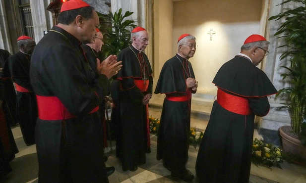 Kardynałowie modlący się przed grobem Franciszka