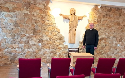 Ks. Jacek Wieczorek w sali z figurą Chrystusa Odkupiciela, wyrzeźbioną przez lokalnego artystę.