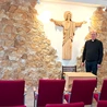 Ks. Jacek Wieczorek w sali z figurą Chrystusa Odkupiciela, wyrzeźbioną przez lokalnego artystę.