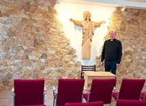 Ks. Jacek Wieczorek w sali z figurą Chrystusa Odkupiciela, wyrzeźbioną przez lokalnego artystę.