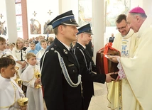 W procesji z darami strażacy przynieśli naczynie na wodę święconą. 