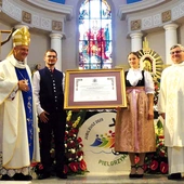  Bp Roman Pindel i ks. kustosz Janusz Talik przy jubileuszowym dekrecie, przyniesionym przez młodych parafian w strojach regionalnych.