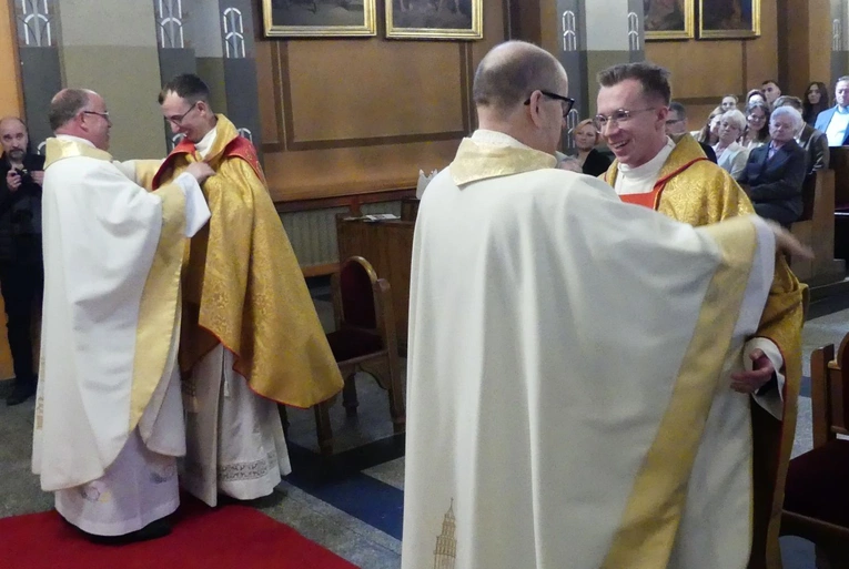 Proboszczowie pomogl neoprezbiterom założyć ornat i przewiesić stułe na sposób kapłański.