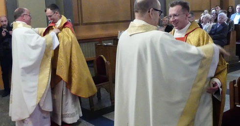 Proboszczowie pomogl neoprezbiterom założyć ornat i przewiesić stułe na sposób kapłański.