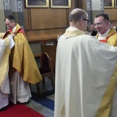 Proboszczowie pomogl neoprezbiterom założyć ornat i przewiesić stułe na sposób kapłański.